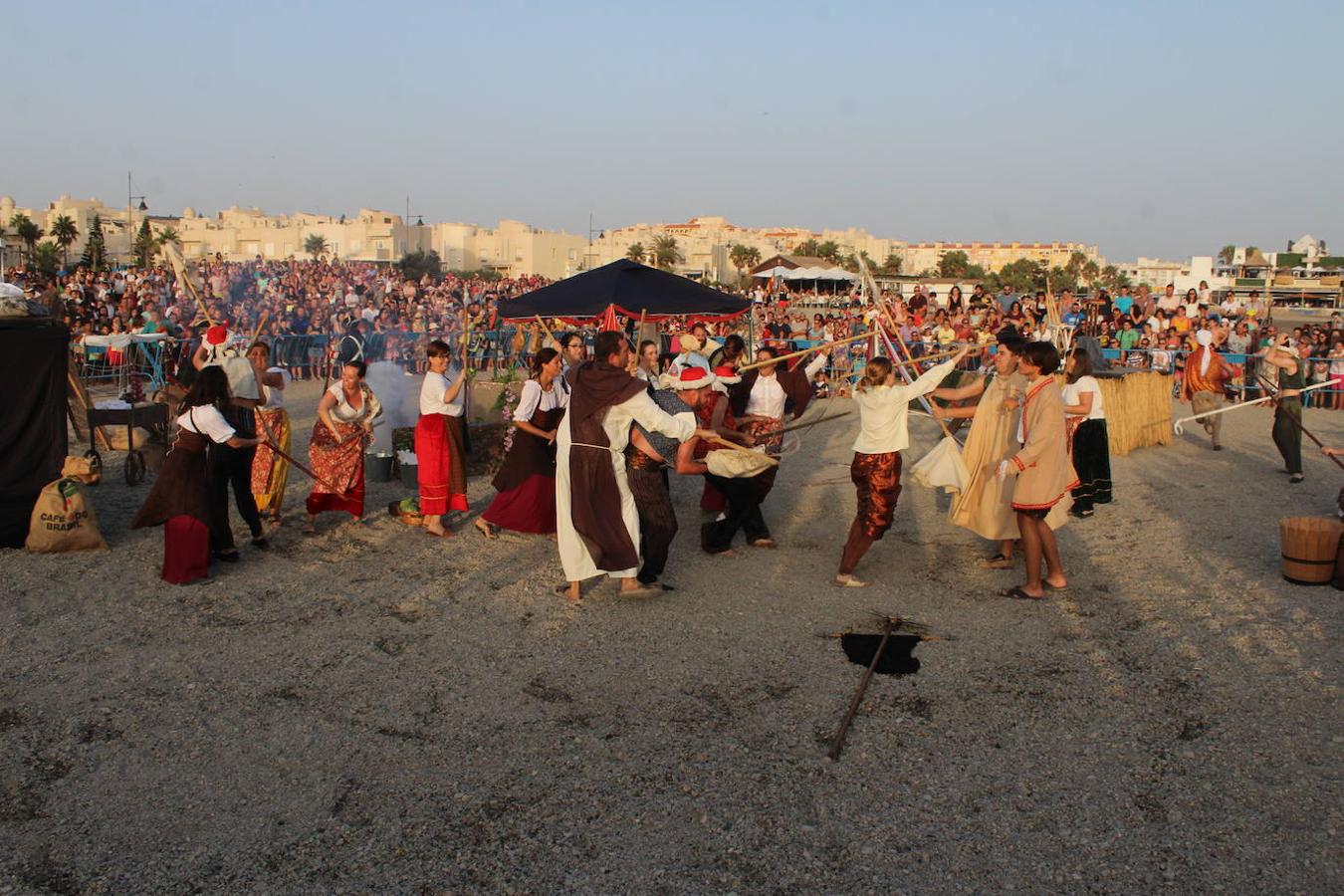 Miles de personas disfrutaron en la tarde noche de ayer con el Desembarco Pirata en la playa de Poniente de Almerimar. Una actividad que cada año gana en adeptos y que ayer permitió volver a acercar un trocito de la historia de esta zona a los asistentes. Un evento de gran plasticidad y trepidante ritmo que se vivió en la playa desde donde luego partió un colorido y animado pasacalles que recorrió el Puerto Deportivo para acabar en la Plaza Batel.