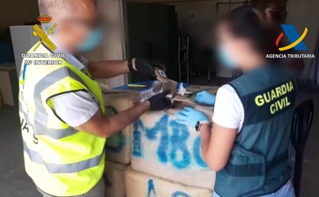 Agentes de Guardia Civil inspeccionan uno de los fardos intervenidos. 