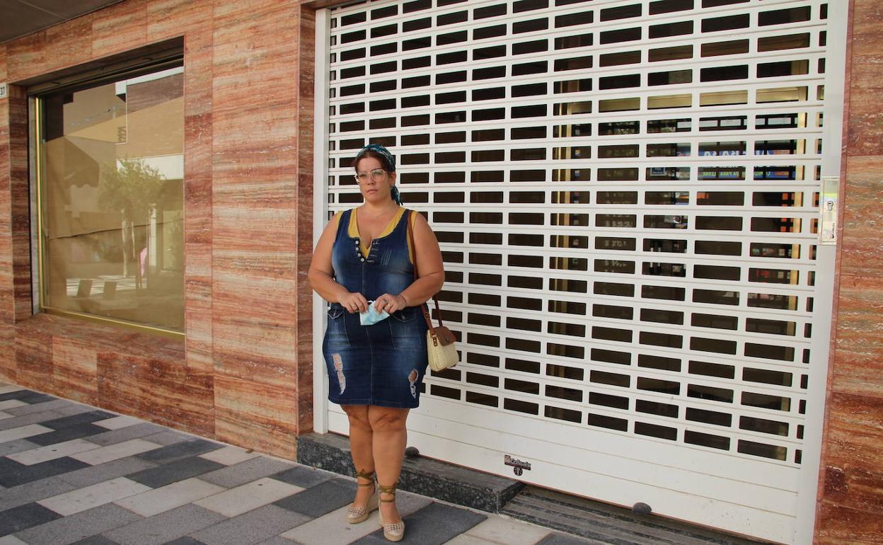 Melani Olivencia en la puerta del que durante seis años ha sido su negocio y su vida, ahora con el escaparate tapado y la persiana bajada. 