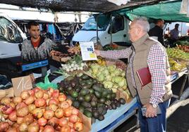 Bernardo Robles entregando las hojas informativas en el mercadillo del núcleo de El Ejido.