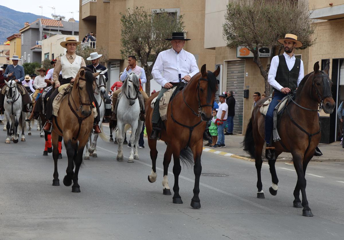 Tres jinetes pasean con sus caballos por una calle de El Ejido.