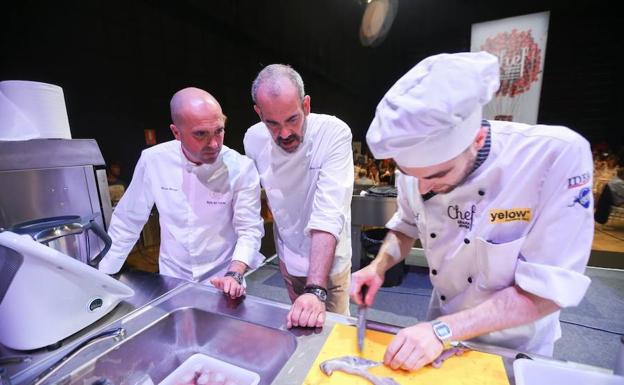 Imagen principal - Concursantes en la gran final bajo la atenta mirada de los cocineros y miembros del jurado. 