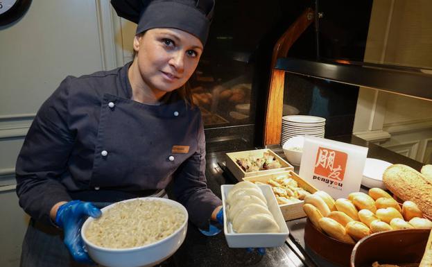 Verónica coloca unas fuentes de arroz blanco hervido y de 'pan bao' –el mollete chino que no tiene corteza y se cocina al vapor–, en la zona 'Peng You', dedicada a la hospitalidad china en el hotel Meliá de Granada. 