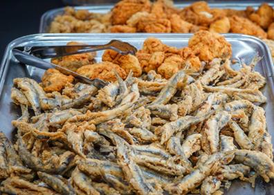 Imagen secundaria 1 - Algunos de los platos de la vitrina que a diario exponen los platos que se cocinan por la mañana. (Arriba) Francisco comprueba como las albondigas se van haciendo a su ritmo. 