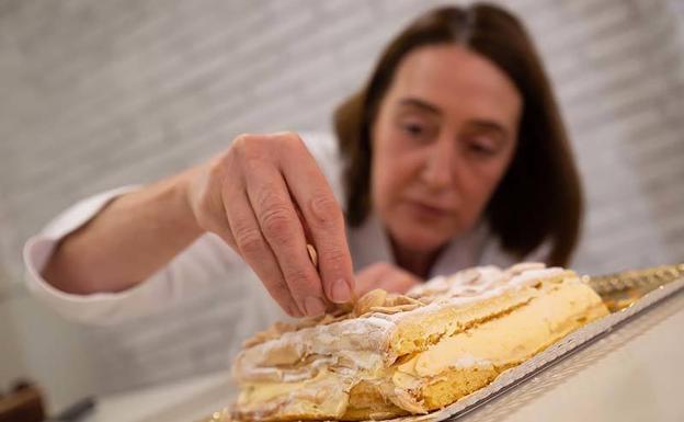 Cristina termina de colocar las almendras sobre una de los pasteles de elaboración propia Tartas