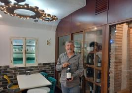 El sumiller David Rodríguez en una taberna de Úbeda junto a una botella de vino.
