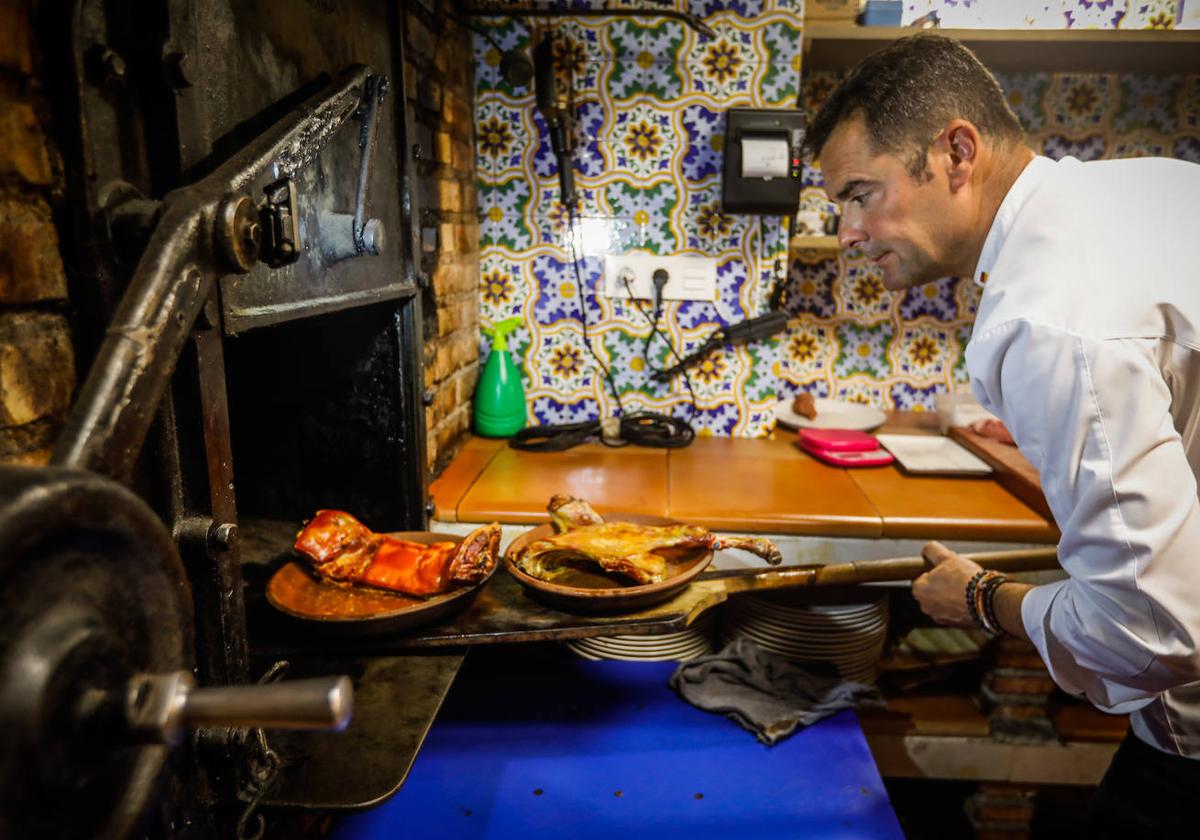 Sergio Lara, 'Cangrejo', trabajando en el horno 'de escopeta' que permite asar las mejores carnes en Asador de la Reina de La Zubia.