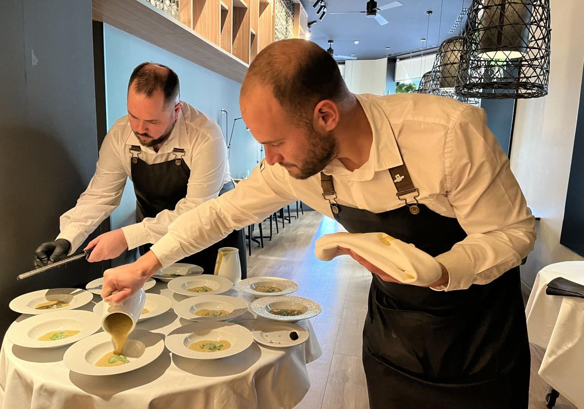 El equipo de sala de Asador Contrapunto prepara la crema de vichyssoise con la papada ibérica y guisantes, rallando la trufa