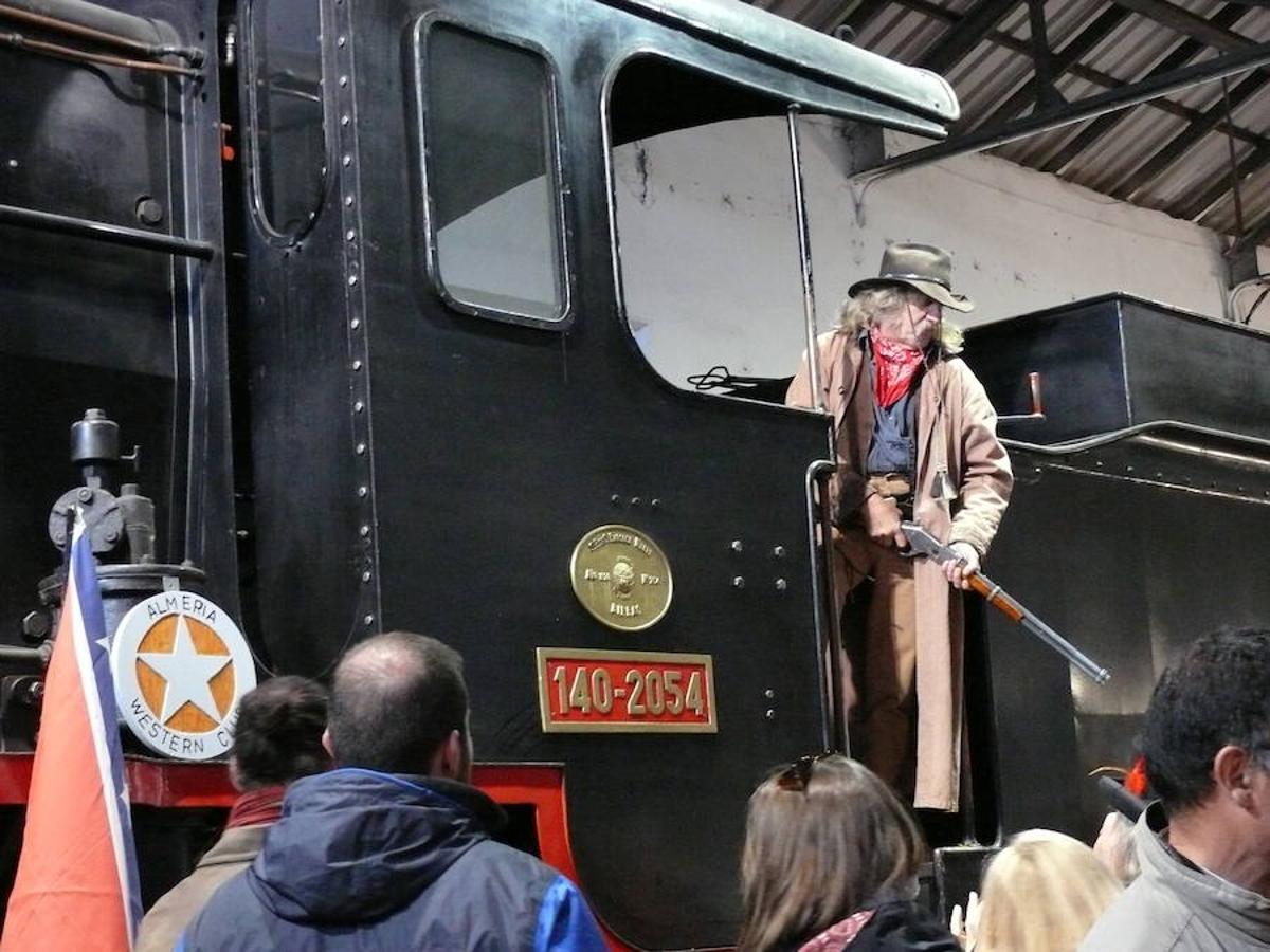 El frío no ha sido obstáculo para que personas de todas las edades se acercaran la tarde de este sábado 3 de febrero al cocherón de la estación donde se alberga la locomotora de vapor Baldwin-La Guadix. Allí se ha inaugurado oficialmente la exposición permanente “Guadix de cine” en la que es posible viajar desde las películas del oeste al templo de “Indiana Jones y la última cruzada” o a los recuerdos de los antiguos cines accitanos y de las películas y series rodadas en Guadix. La alcaldesa de Guadix, Inmaculada Olea Laguna, el concejal de Turismo, Iván López Ariza, y la técnica de Turismo, Toni Requena, han sido los guías en este acto que ha estado amenizado por Almería Western Club.