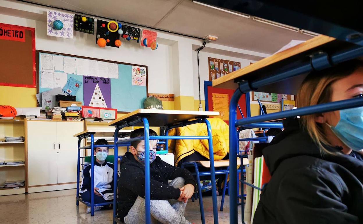 El alumnado, a salvo debajo de los pupitres.