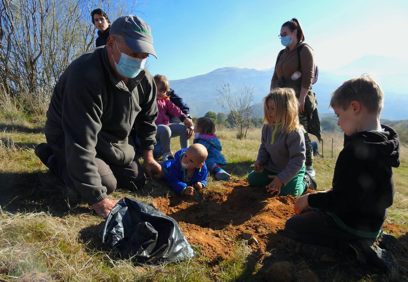 Fotos: Un centenar de personas reforestan el Camino de los Neveros