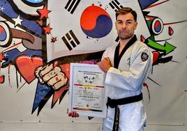 El maestro hueteño de taekwondo Rubén Hita muestra el título.