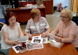 María Angustias Lafuente, Juana de Miguel y Encarnita Jiménez, repasando fotos y recortes en su sede.