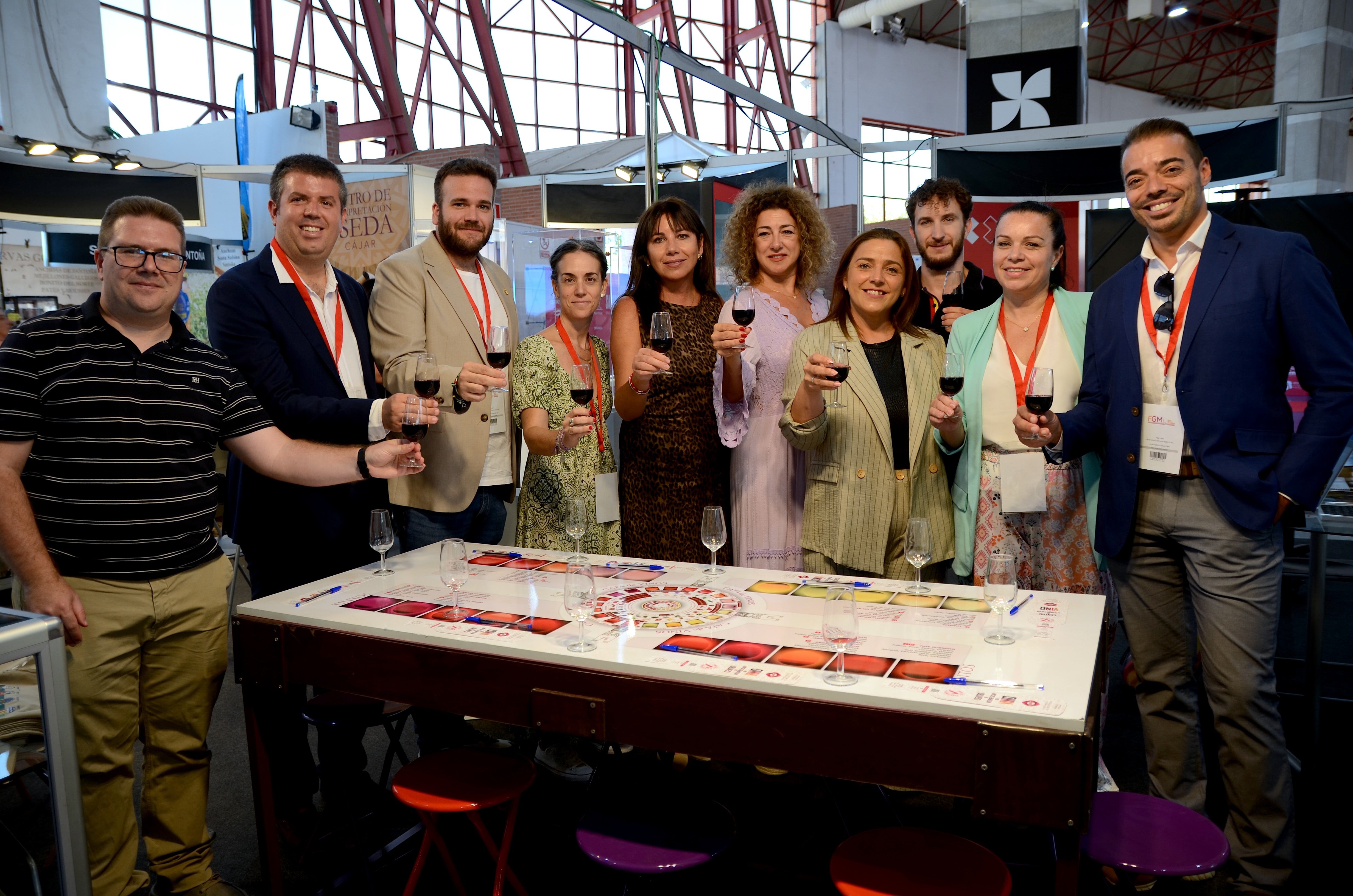 Representantes de Monachil, Huétor Vega, Cájar y La Zubia brindan sobre una mesa de catas en el estand hueteño.