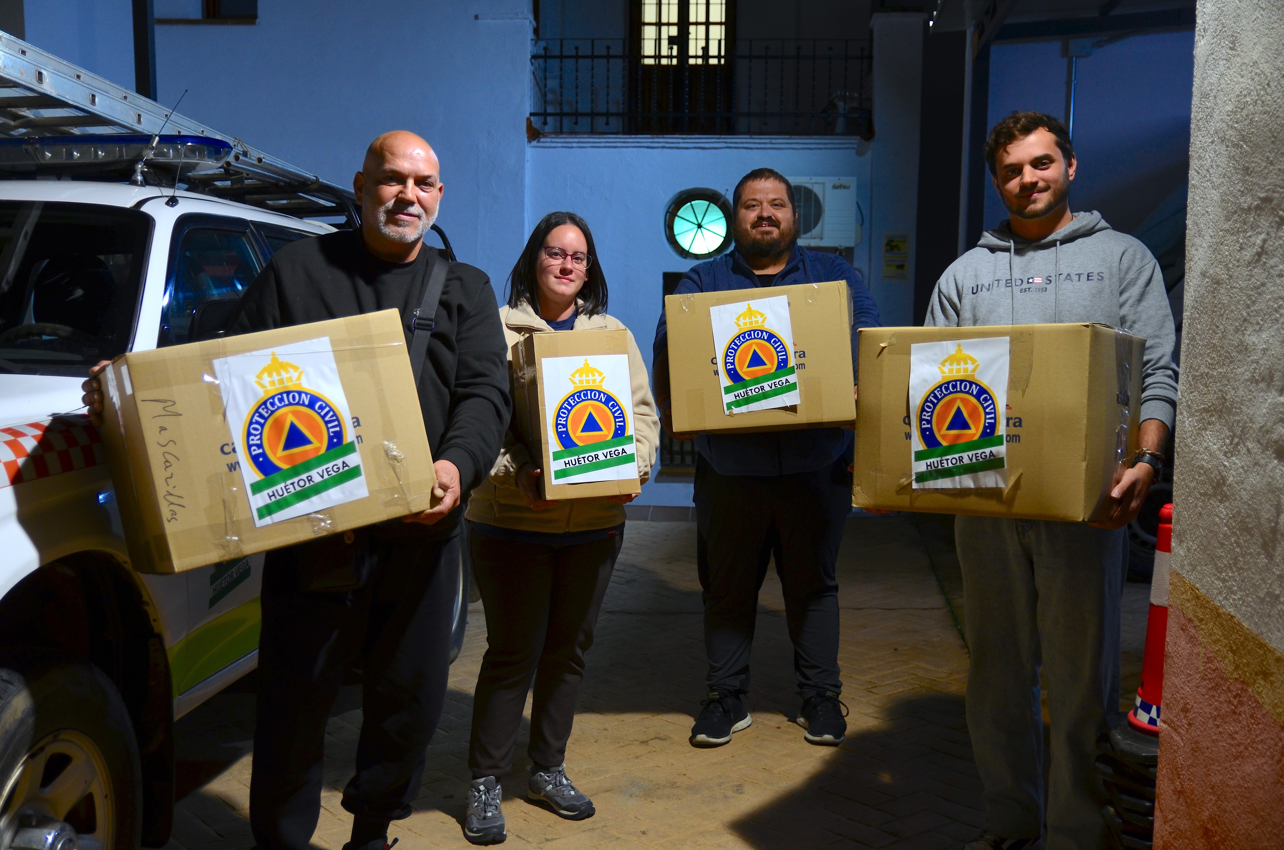 Ignacio, Jessica, Jaime y Álvaro, cargando cajas para Valencia en la sede de Protección Civil de Huétor Vega.
