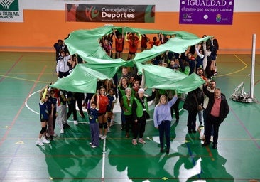 Representantes de la corporación municipal, miembros de la Junta Local de la AECC y jóvenes del Club Voleibol Huétor Vega, formando un gran lazo.