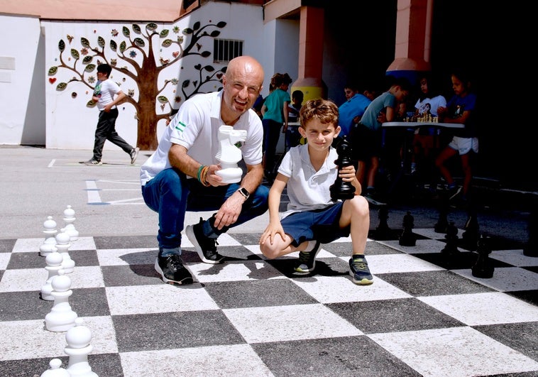 El profesor Santiago Amaro y David Martínez del Paso, en uno de los tableros dispuestos en el patio del colegio.