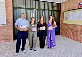 Miembros del equipo de gobierno entregan las agendas y el cuaderno.