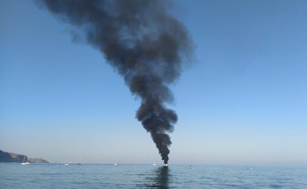 Torre de humo negro procendente del incendio de una embarcación.
