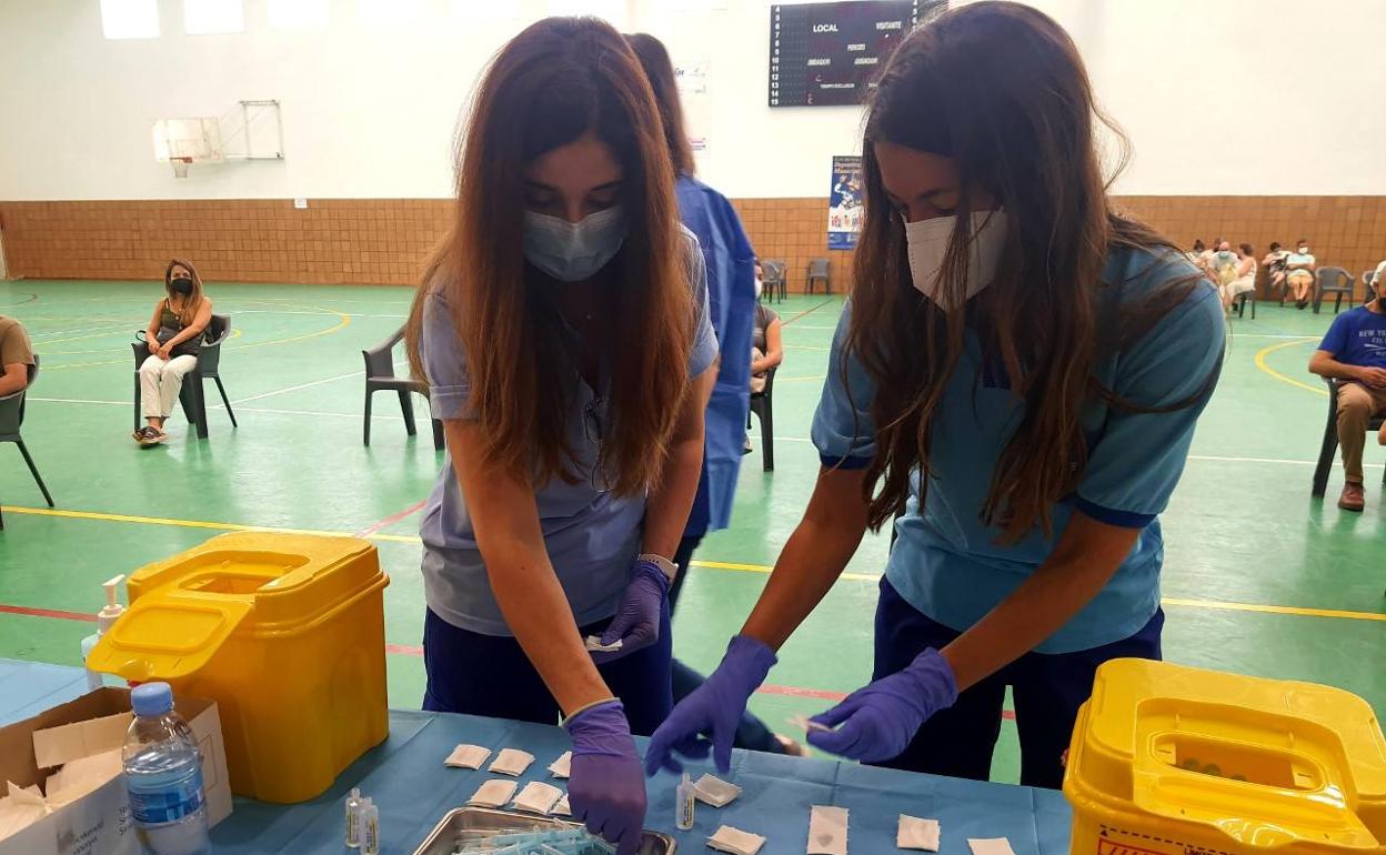 Profesionales sanitarias preparan dosis de la vacuna frente a la covid en un punto de vacunación masiva. 