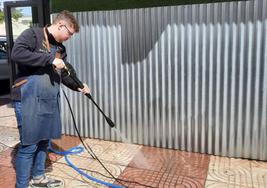 Benjamín Ferrer limpia la acera de su propio comercio.