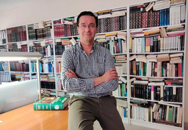 Raúl Pomares en una sala rodeado de libros.