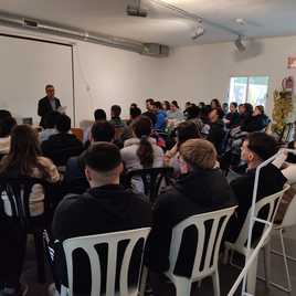 Varios alumnos prestan atención al alcalde de la localidad.