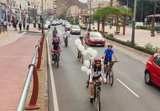 Varios vecinos pasean durante el día en bicicleta por una de las carreteras de Aguadulce.