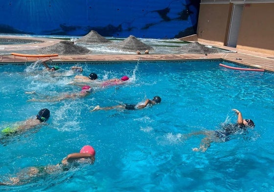 Niños nadando en la piscina.