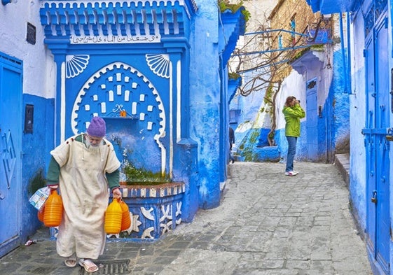 Una mujer fotografía un lugar de Chaouen, en Marruecos.