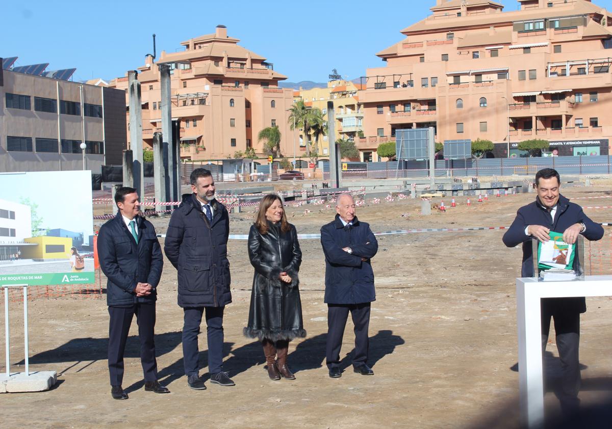 El presidente de la Junta de Andalucía, Juanma Moreno Bonilla, mete una bandera de Andalucía en una urna en Roquetas de Mar.