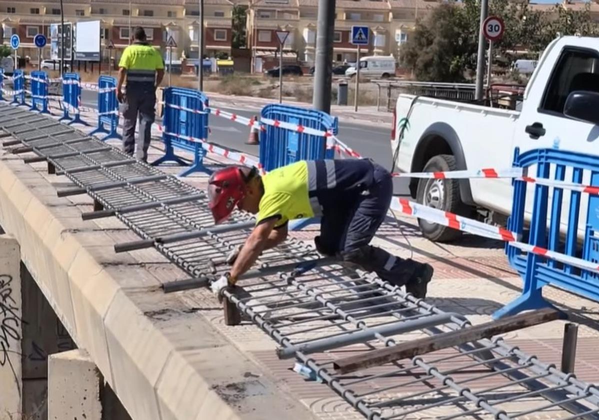 Un trabajador se encarga de reparar una de las vallas metálicas.