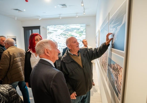 El alcalde de Roquetas, Gabriel Amat, visualiza uno de los paneles con imágenes históricas del cambio del municipio costero.