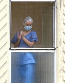 Imagen secundaria 2 - Concentración bajo las banderas a media asta, palabras del gerente y una compañera sumándose al homenaje desde una ventana.