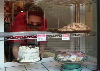 Imagen secundaria 1 - Bajando la persiana de un establecimiento, Rosa intentando mantener el negocio con pedidos de dulces y vista de la calle Mesones donde se encuentra Bolsos Pruden.