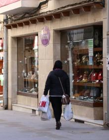 Imagen secundaria 2 - Bajando la persiana de un establecimiento, Rosa intentando mantener el negocio con pedidos de dulces y vista de la calle Mesones donde se encuentra Bolsos Pruden.