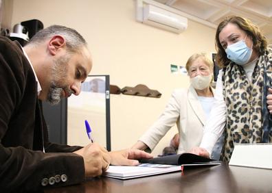 Imagen secundaria 1 - Vicente Ruiz en su despacho, firmando ejemplares de su libro y galleta marinera con sopa de tropezones.