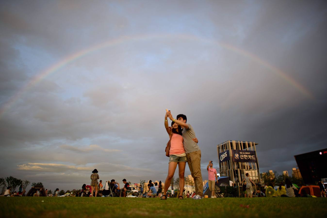 Juerguistas toman fotografías bajo un arco iris en el Rock Festival Pentaport en Incheon.