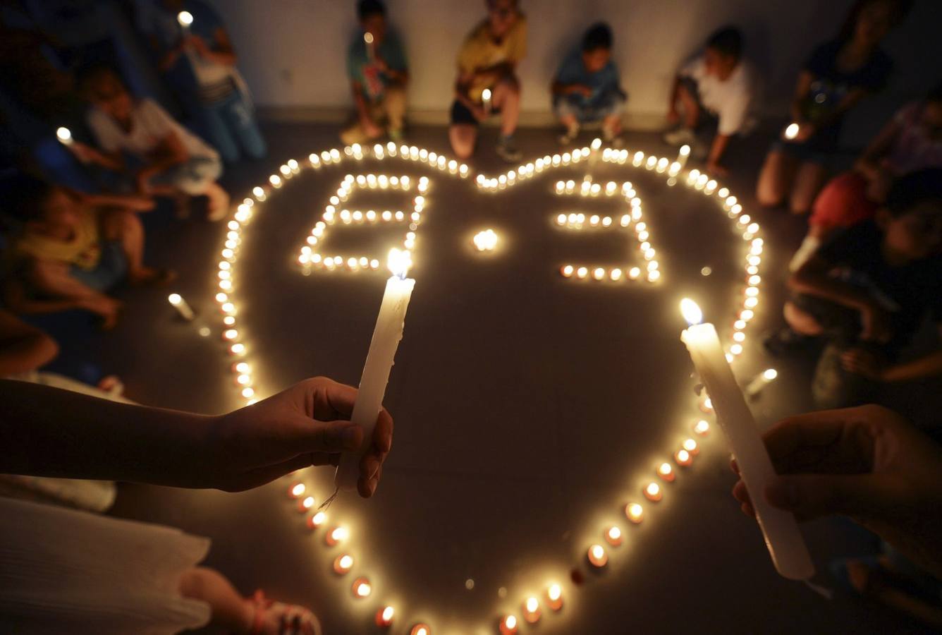 Los niños sostienen velas mientras rezan por los afectados después del terremoto de magnitud 6,3 golpeó la ciudad Longtoushan, condado Ludian de Zhaotong, provincia de Yunnan, en Yangzhou, provincia de Jiangsu.