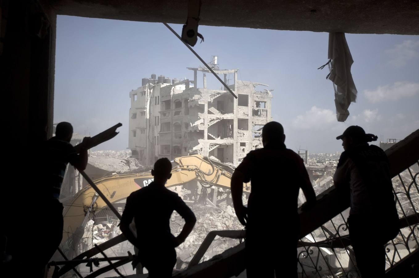 Hombres palestinos inspeccionan la destrucción parcial del barrio de al-Tufah de Gaza City.
