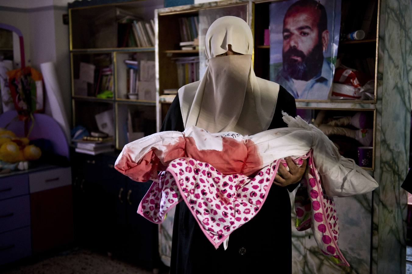 Una mujer palestina sostiene el cuerpo de un niño después de que su cuerpo fue llevado a la casa de la familia de la morgue antes de que el cortejo fúnebre en la ciudad de Gaza.