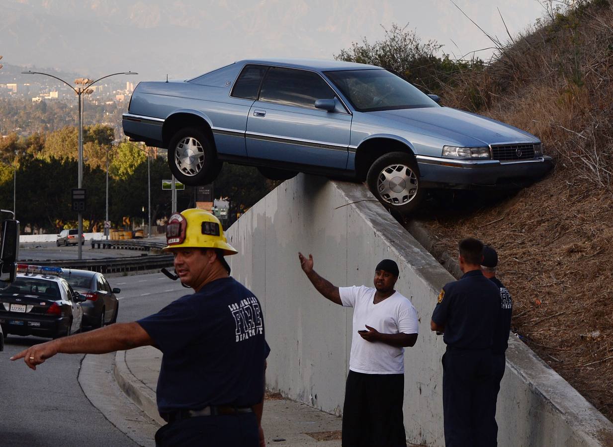 Un coche encima de un terraplén después de perder el control y el arrastre hasta el muro de contención de hormigón en South La Brea Ave en Baldwin Hills, Los Angeles.