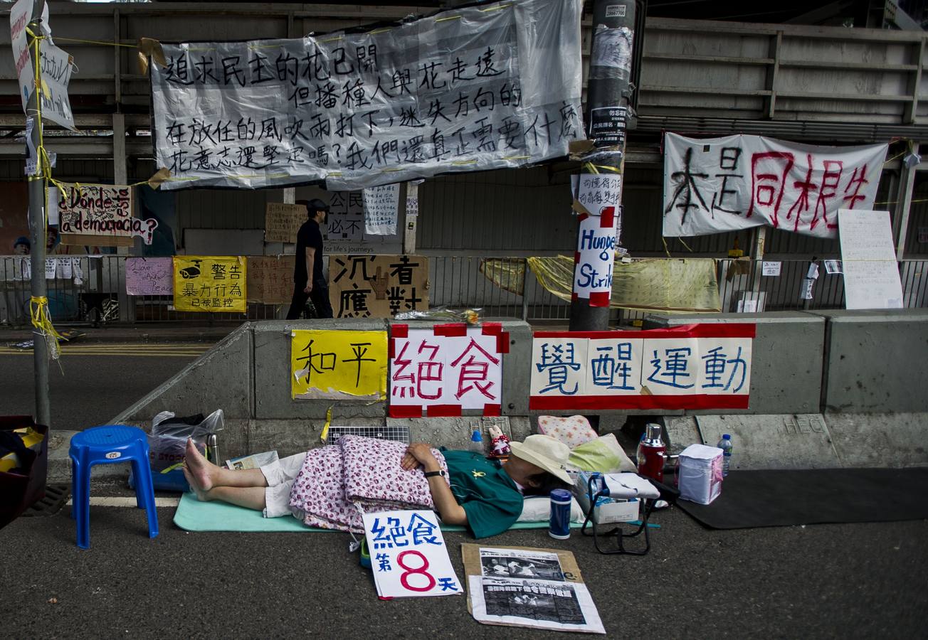 Un hombre toma un descanso rodeado de pancartas y carteles en el distrito de Almirantazgo en Hong Kong.