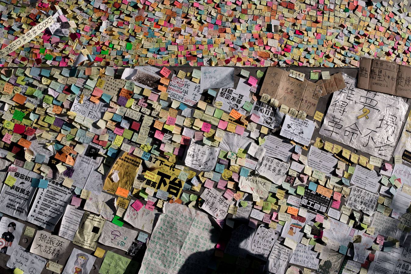La sombra de un manifestante pro-democracia se proyecta sobre una pared.