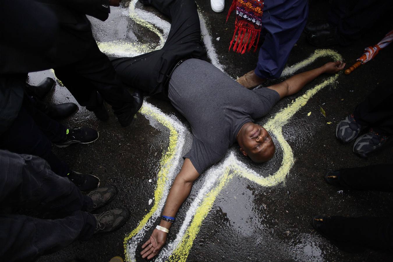 Pastor Charles Burton ha esbozado su cuerpo con tiza para reproducir una escena del crimen, mientras él y otros manifestantes protestar por el asesinato de Michael Brown.