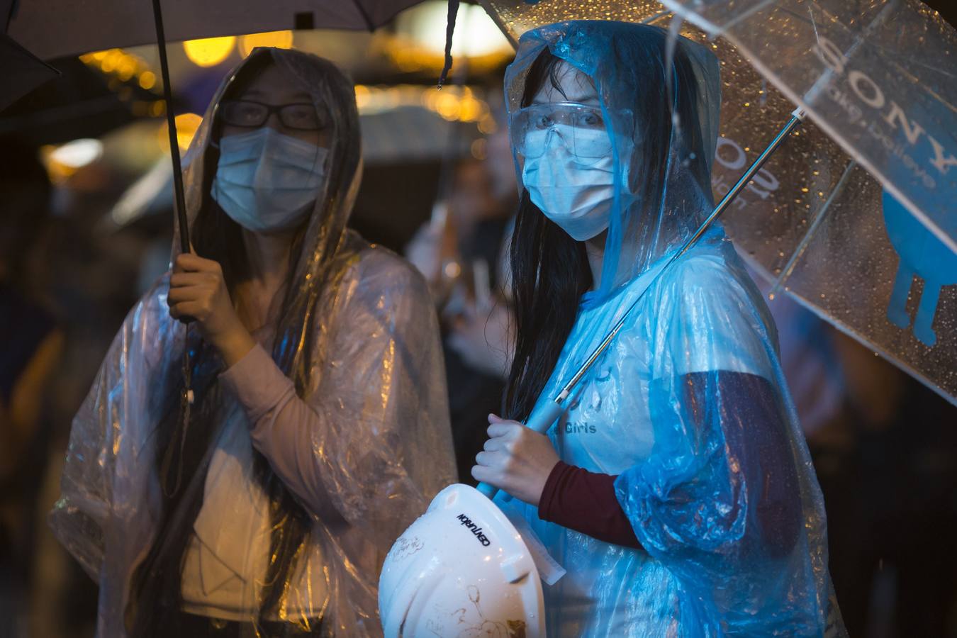 Los manifestantes pro-democracia sostienen los paraguas durante la lluvia pesada en el distrito comercial de Mongkok Hong Kong.