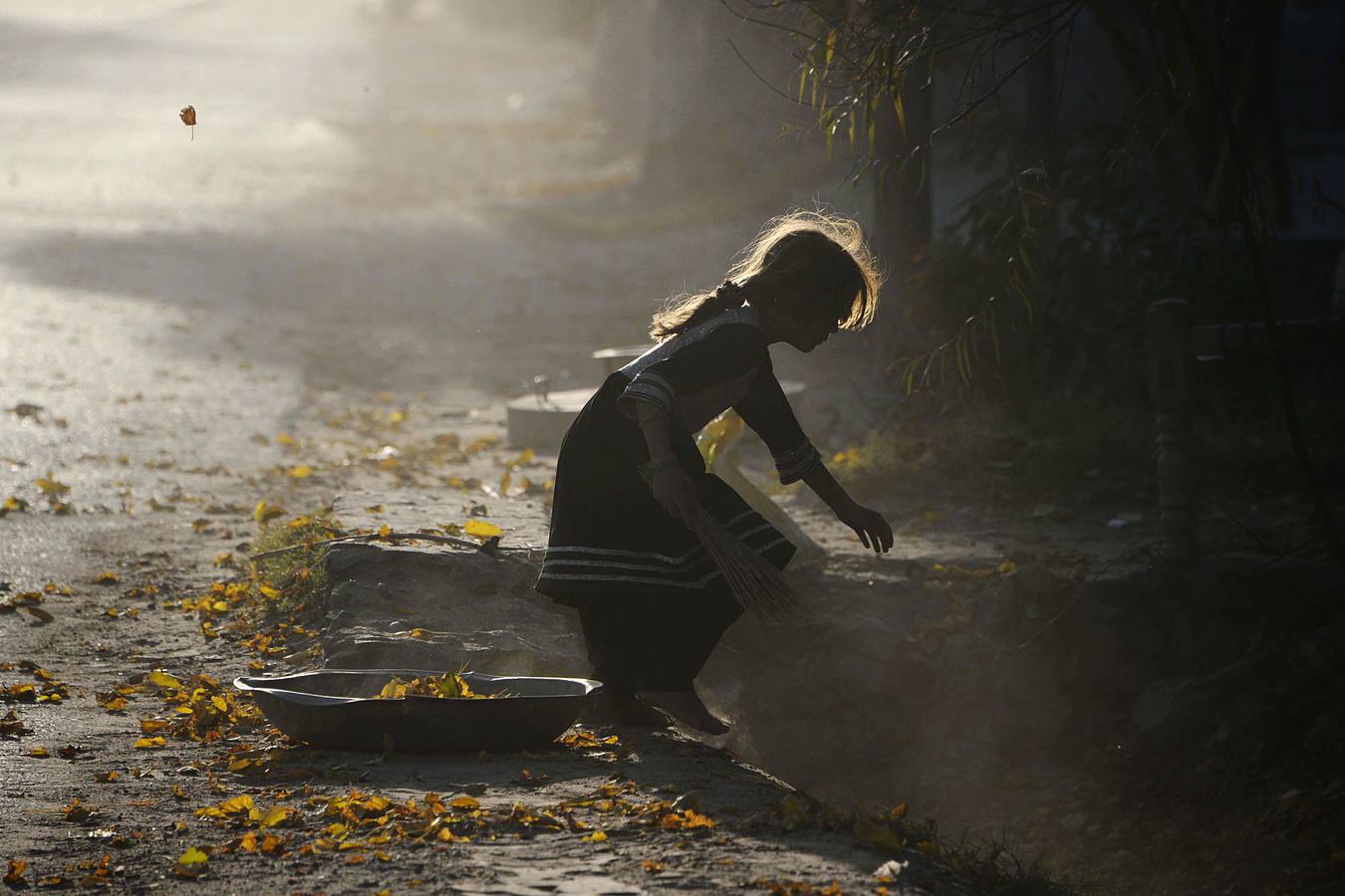 Niña afgana recoge las hojas caídas del otoño en Jalalabad.