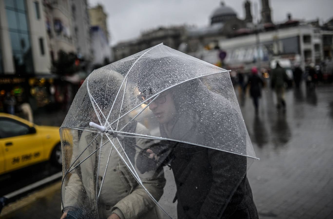 Dos jóvenes intentan caminar en la avenida Istiklal durante una tormenta en Estambul.