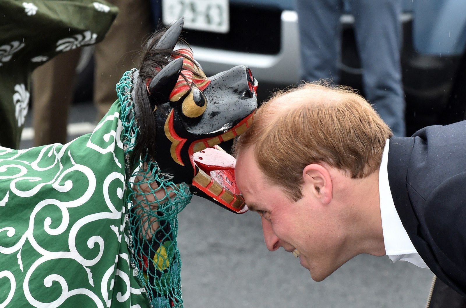 El príncipe Guillermo, es recibido por una danza del león durante su visita a la Chime de centro comercial Esperanza en Onagawa.