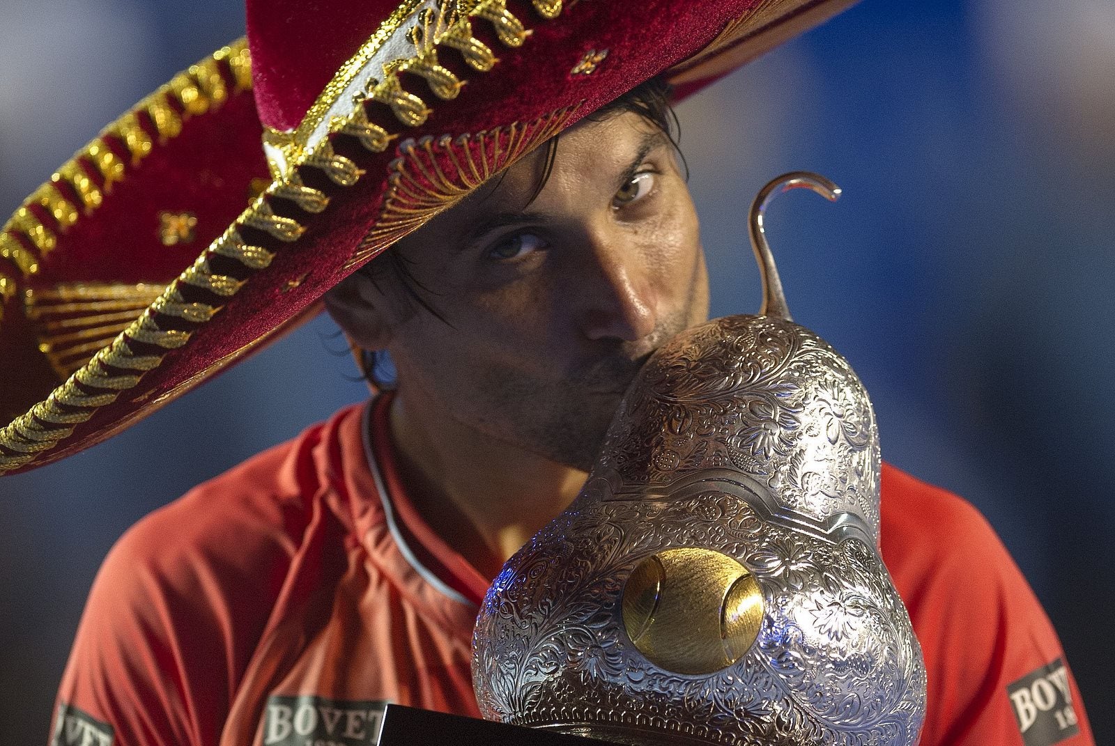 Ferrer lleva un sombrero tradicional mexicana mientras sostiene el trofeo de ganador del partido de tenis México ATP Open en Acapulco.